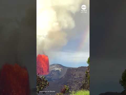Erupting volcano and rainbow share sky in Hawaii thumbnail
