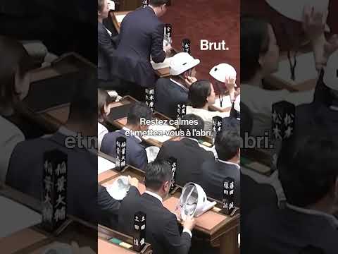 Des parlementaires japonais enfilent des casques lors d'un exercice de simulation de séisme. thumbnail