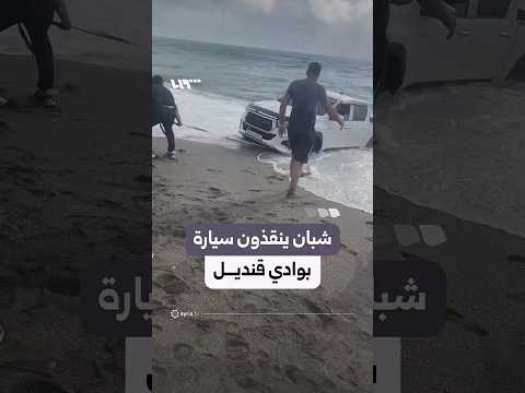 شبان يحاولون سحب سيارة علقت بالرمال في وادي قنديل باللاذقية thumbnail