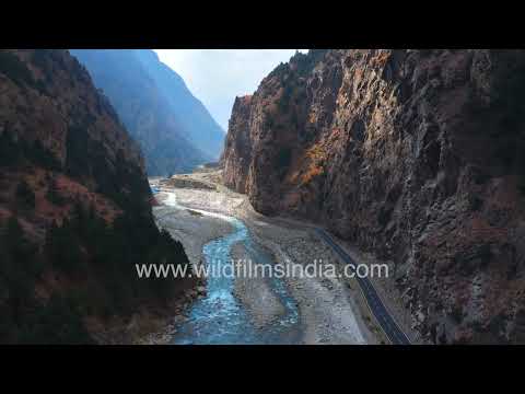 Himalayan mountain landscape featuring a winding road and bridge in Uttarakhand India thumbnail