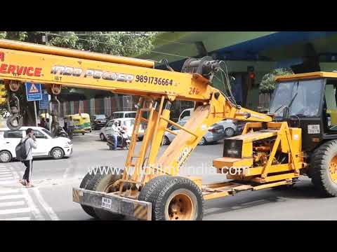 Mobile crane lifts concrete barrier during road work in Delhi thumbnail